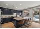 Kitchen with stainless appliances, large island with bar seating, wood floors, and access to the outdoor pool at 3523 E Alfalfa Dr, Gilbert, AZ 85298