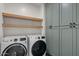 Laundry room with modern washer and dryer, cabinets, and shelving at 3523 E Alfalfa Dr, Gilbert, AZ 85298