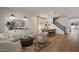 Bright living room with wood floors, staircase, designer lighting, and a view of the backyard and pool at 3523 E Alfalfa Dr, Gilbert, AZ 85298