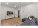 Comfortable living room with hardwood floors, a gray sectional sofa, and a large TV at 3523 E Alfalfa Dr, Gilbert, AZ 85298