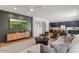 Open-concept living room with a large TV, modern furniture, and seamless flow into the kitchen at 3523 E Alfalfa Dr, Gilbert, AZ 85298
