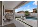 Relaxing pool patio with outdoor seating under a covered area, next to a lush pool and yard at 3523 E Alfalfa Dr, Gilbert, AZ 85298