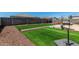Backyard with faux grass, gravel accents, and a concrete block fence at 38005 W Montserrat St, Maricopa, AZ 85138