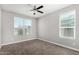 Neutral bedroom showcasing a window letting in lots of natural light and a ceiling fan at 38005 W Montserrat St, Maricopa, AZ 85138