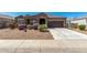 Charming single-story home featuring a gravel front yard, desert landscaping, and a two-car garage at 38005 W Montserrat St, Maricopa, AZ 85138