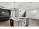 Open kitchen with black island, stainless appliances, and a seamless flow to the living area at 38005 W Montserrat St, Maricopa, AZ 85138