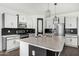 This modern kitchen features black and white color scheme, stainless steel appliances, and a central island at 38005 W Montserrat St, Maricopa, AZ 85138