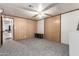 This is a large bedroom with a ceiling fan, wood paneled walls, and carpeted floors at 3807 W Abraham Ln, Glendale, AZ 85308