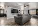 Comfortable living room with gray sofa, modern entertainment center, and stylish luxury vinyl plank flooring at 3807 W Abraham Ln, Glendale, AZ 85308