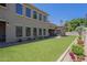 Side yard featuring artificial turf, desert landscaping, and a view of the house at 3812 E Camelback Rd, Phoenix, AZ 85018