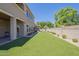 Spacious backyard with artificial turf and desert landscaping surrounding the perimeter at 3812 E Camelback Rd, Phoenix, AZ 85018