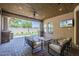 Comfortable covered patio with ceiling fan, TV, and views of a green lawn at 3812 E Camelback Rd, Phoenix, AZ 85018