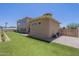 Side yard with artificial turf, desert landscaping, and a glimpse of the covered patio at 3812 E Camelback Rd, Phoenix, AZ 85018