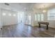 Spacious living room features wood flooring, plenty of windows, and a foosball table for entertaining at 3812 E Camelback Rd, Phoenix, AZ 85018