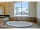 Primary bathroom soaking tub boasts mountain views, along with tile surround and fixtures at 3812 E Camelback Rd, Phoenix, AZ 85018
