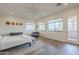 Airy primary bedroom boasting wood-look flooring, view windows, ceiling fan, and door to private patio at 3812 E Camelback Rd, Phoenix, AZ 85018