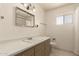 Bathroom featuring a white sink, mirror, toilet, cabinets and window at 405 E Thunderbird Trl, Phoenix, AZ 85042