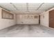 Spacious two-car garage with concrete flooring, storage, and a side exit door at 405 E Thunderbird Trl, Phoenix, AZ 85042