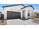 Inviting white home showcases a gray garage door, covered entrance, and charming curb appeal at 4451 N 203Rd Ave, Buckeye, AZ 85396