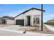 Stylish white home boasts a covered porch, gray garage door, and attractive desert landscaping at 4451 N 203Rd Ave, Buckeye, AZ 85396