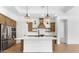 Modern kitchen boasts an island, stainless steel appliances, open shelves, and subway tile backsplash at 4451 N 203Rd Ave, Buckeye, AZ 85396