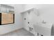 Bright laundry room featuring patterned floors, a utility sink, and window at 4451 N 203Rd Ave, Buckeye, AZ 85396