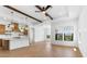 Open concept living room featuring wood-look tile flooring and modern fixtures with breakfast bar overlooking the kitchen at 4451 N 203Rd Ave, Buckeye, AZ 85396