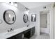 Bathroom featuring dual sinks, dark cabinets, oval mirrors, and dark fixtures at 4790 E Navajo St, Phoenix, AZ 85044