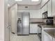 Bright kitchen features white cabinets, stainless steel refrigerator, and tiled floors at 4790 E Navajo St, Phoenix, AZ 85044