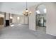 Open-concept living room featuring grey carpet, fireplace, and chandelier at 4790 E Navajo St, Phoenix, AZ 85044