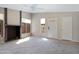 A spacious living room featuring neutral paint, plush carpet, a fireplace, and a bright white front door at 4790 E Navajo St, Phoenix, AZ 85044