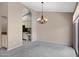 Living room featuring neutral walls, grey carpet, and view into the kitchen at 4790 E Navajo St, Phoenix, AZ 85044