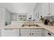 Bright kitchen featuring a double sink, granite countertops, and white cabinetry with a view to the living area at 4901 E Kelton Ln # 1270, Scottsdale, AZ 85254