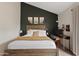 Cozy main bedroom with a dark accent wall, light-colored carpet, and a wood bed frame at 4901 E Kelton Ln # 1270, Scottsdale, AZ 85254