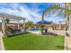 Lush backyard featuring pristine artificial turf, a sparkling pool, and ample outdoor entertaining space at 5218 N Tiller Dr, Litchfield Park, AZ 85340