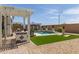 Inviting backyard featuring pool, outdoor kitchen, lawn, and recreation area for entertaining at 5218 N Tiller Dr, Litchfield Park, AZ 85340