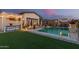 Enjoy the spacious backyard with pool, outdoor kitchen, artificial grass, and shaded seating area at 5218 N Tiller Dr, Litchfield Park, AZ 85340