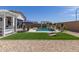Beautiful backyard with a pool, putting green, outdoor kitchen, and ample entertaining space at 5218 N Tiller Dr, Litchfield Park, AZ 85340