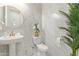 Stylish powder room featuring modern fixtures, marble accent wall, and decorative mirror at 5218 N Tiller Dr, Litchfield Park, AZ 85340