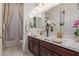 Bathroom with dual sinks, dark wood cabinets, and decorative light fixtures at 5218 N Tiller Dr, Litchfield Park, AZ 85340