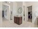 Bright hallway featuring tile floors and a decorative cabinet with a modern round mirror at 5218 N Tiller Dr, Litchfield Park, AZ 85340