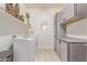 Functional laundry room featuring gray cabinets, a washing machine, dryer and shelving for storage and decor at 5218 N Tiller Dr, Litchfield Park, AZ 85340