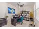 This home office has tile floors, modern shelving, a ceiling fan, and a dark desk with a comfortable blue chair at 5218 N Tiller Dr, Litchfield Park, AZ 85340