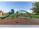 Community playground showcasing a green slide and overhead apparatus for climbing and active play at 5218 N Tiller Dr, Litchfield Park, AZ 85340