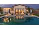 Inviting backyard pool with patio, luxurious seating, and covered outdoor living area at twilight at 5218 N Tiller Dr, Litchfield Park, AZ 85340