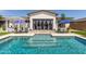Stunning pool with Baja step, covered patio, and blue umbrellas, perfect for backyard relaxation at 5218 N Tiller Dr, Litchfield Park, AZ 85340