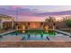 A stunning backyard pool surrounded by desert landscaping, brick pavers, and a decorative privacy wall at 5218 N Tiller Dr, Litchfield Park, AZ 85340