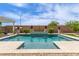 A pristine pool surrounded by manicured landscaping and travertine pavers, perfect for relaxation at 5218 N Tiller Dr, Litchfield Park, AZ 85340