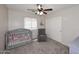 Cozy Bedroom featuring a gray crib, comfy chair, and a ceiling fan for a relaxing atmosphere at 537 S 153Rd Ln, Goodyear, AZ 85338