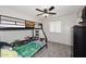 View of a carpeted bedroom showcasing a bunk bed, window, and ceiling fan at 537 S 153Rd Ln, Goodyear, AZ 85338